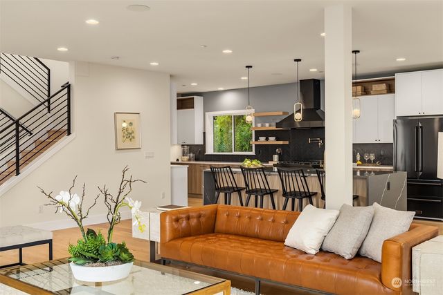 a living room with furniture kitchen view and a large window