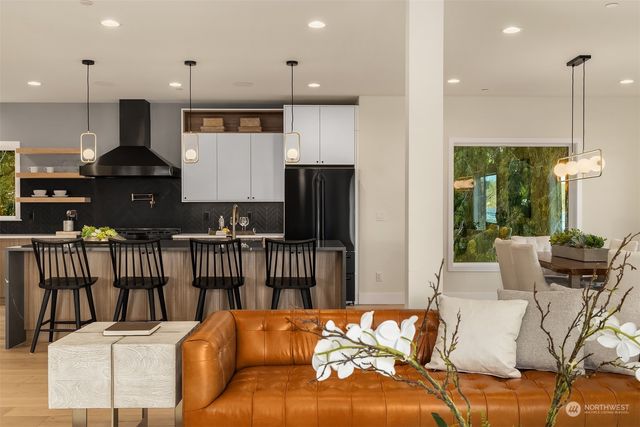 a living room with furniture kitchen view and a window