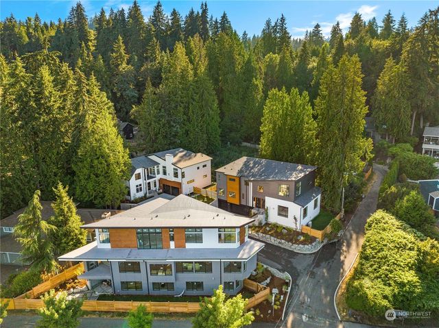 an aerial view of a residential apartment building with a yard and large trees