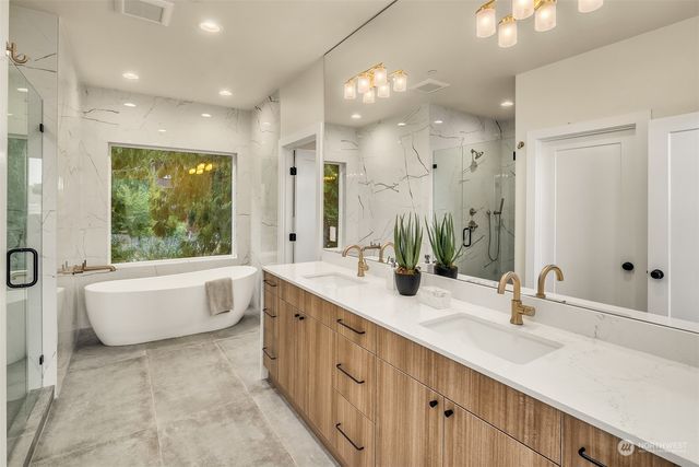 a bathroom with a double vanity sink large mirror and a bathtub