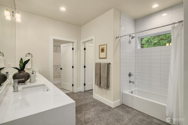a bathroom with a tub a sink and a window