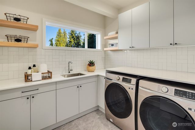 a utility room with sink dryer and washer