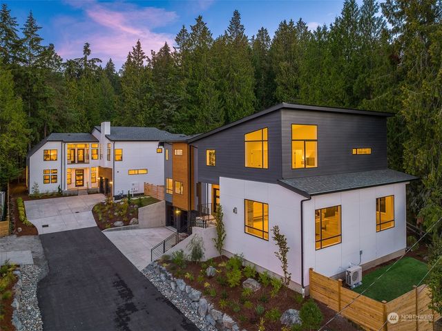 a front view of a house with trees and yard