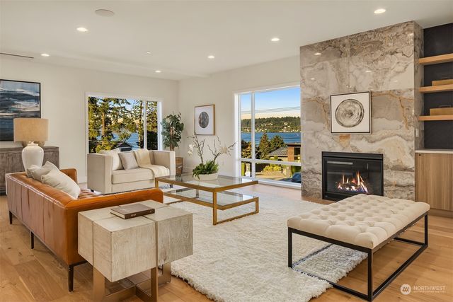 a living room with fireplace furniture and a large window