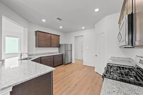 a kitchen with stainless steel appliances granite countertop a sink stove and refrigerator