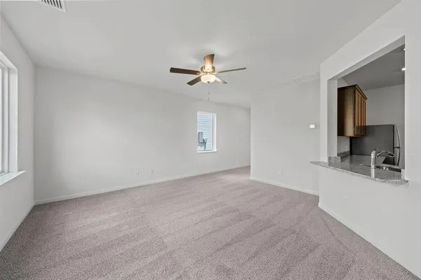 a view of a room with a ceiling fan and a window