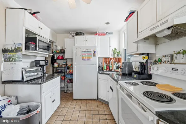 a kitchen with refrigerator a stove a sink and cabinets