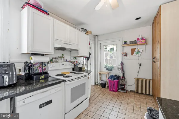 a kitchen with white cabinets and appliances