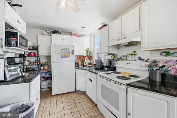 a kitchen with refrigerator a stove a sink and cabinets
