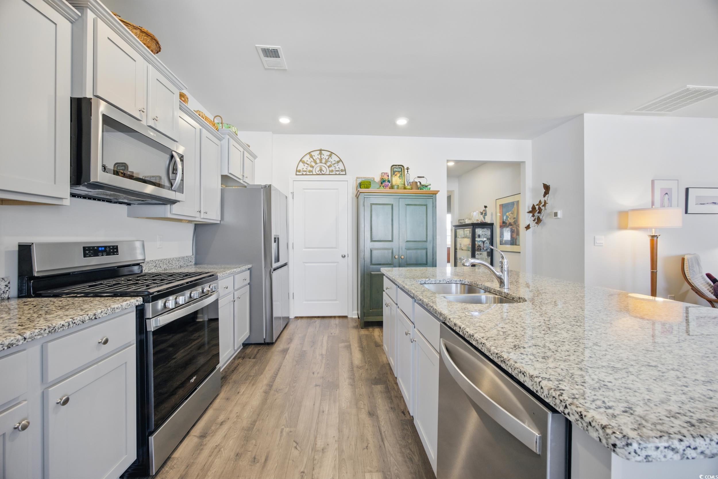 1723 Perthshire Loop Myrtle Beach, SC 29579 - Photo 13 of 34 Kitchen with appliances with stainless steel finishes, a sink, light wood-style flooring, recessed lighting, and light stone counters