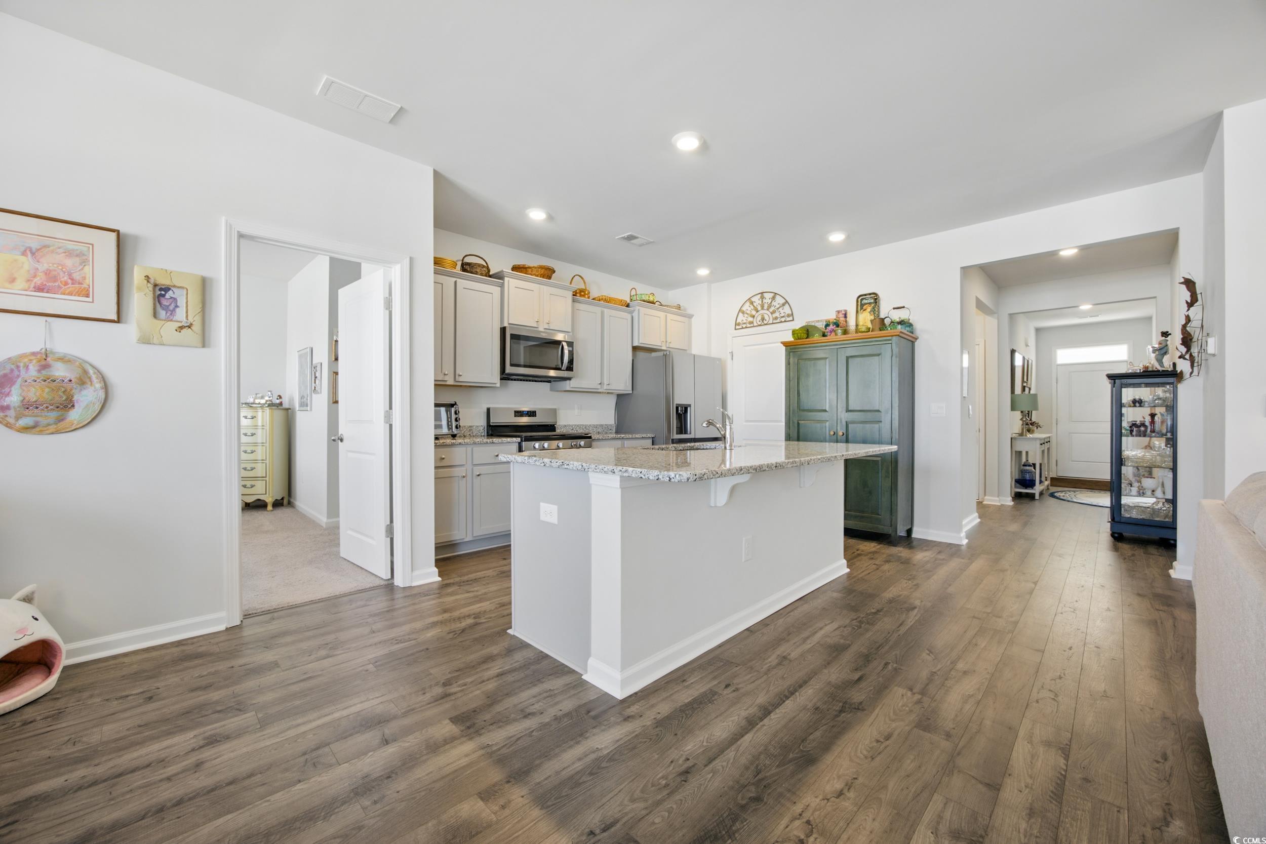 1723 Perthshire Loop Myrtle Beach, SC 29579 - Photo 17 of 34 Kitchen featuring appliances with stainless steel finishes, a center island with sink, dark wood-style floors, recessed lighting, and baseboards