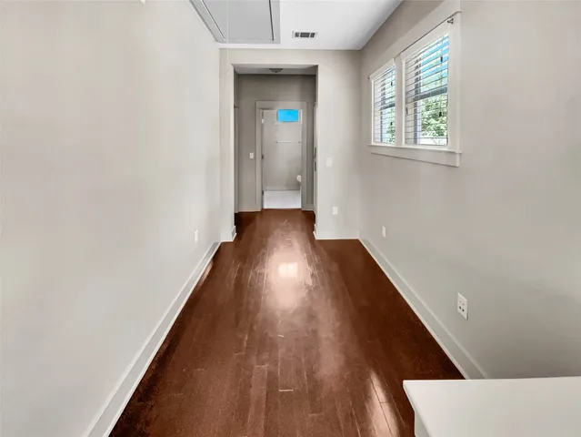 a view of a hallway with wooden floor and staircase