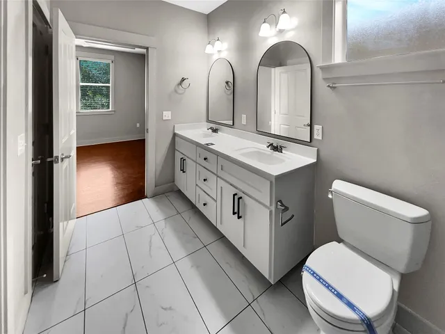 a bathroom with a toilet sink and mirror