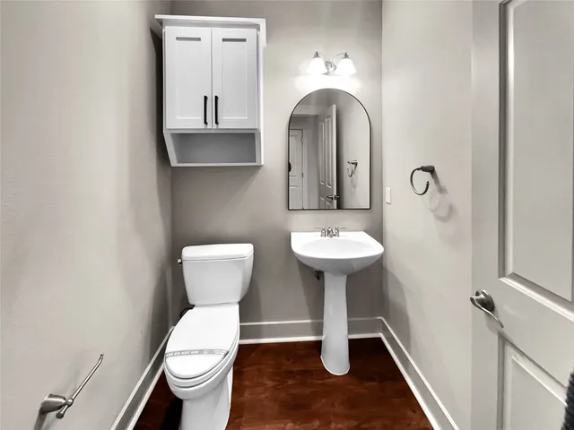 a bathroom with a toilet sink and mirror