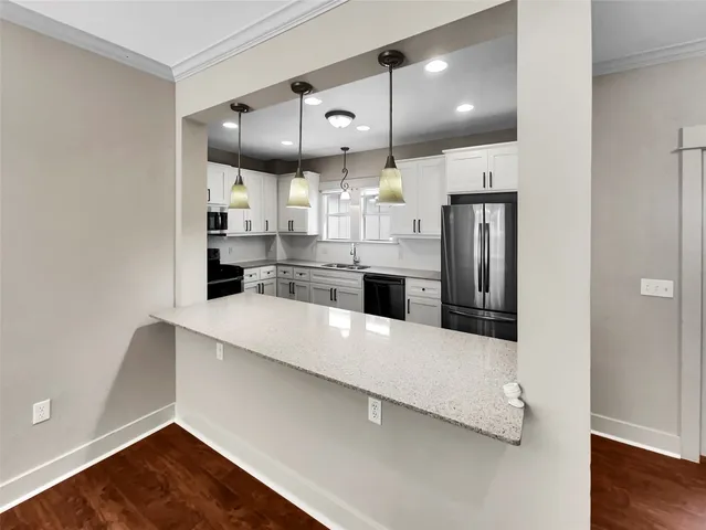 a large kitchen with stainless steel appliances a large counter top