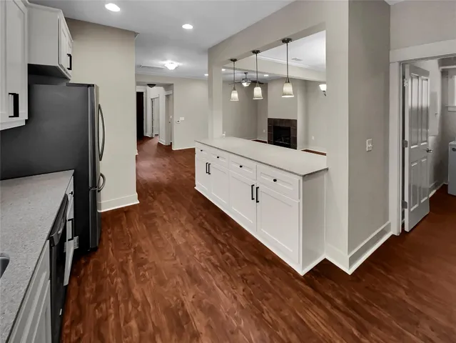 a view of a kitchen with refrigerator and wooden floor