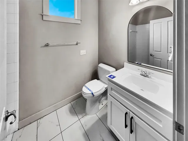a bathroom with a sink a toilet and a mirror