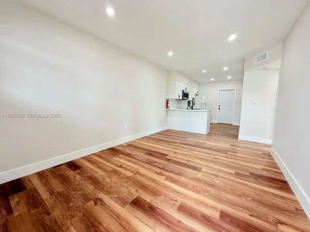 a view of a room with wooden floor and white walls