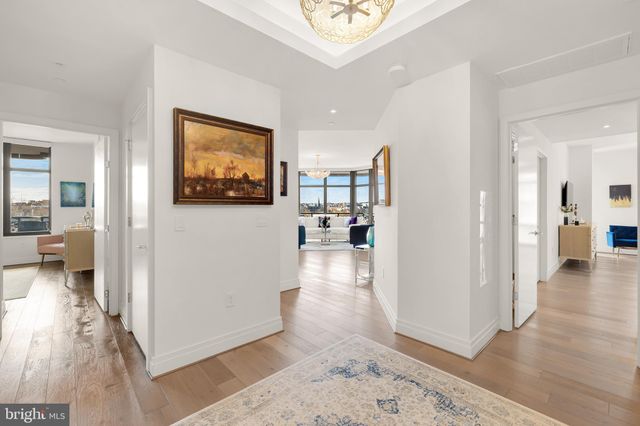 a view of a hallway view with wooden floor and a living room