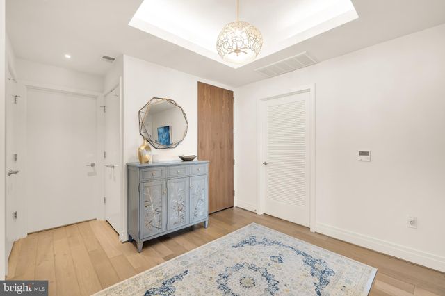 a view of a bedroom with wooden floor and a chandelier fan