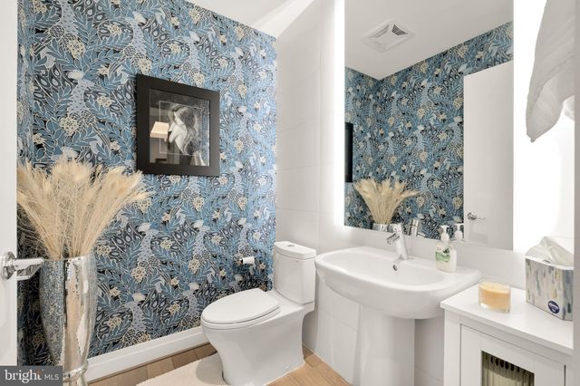 a bathroom with a sink and mirror with toilet