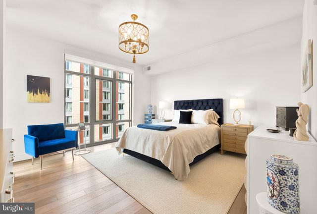 a bedroom with a large bed and a chandelier