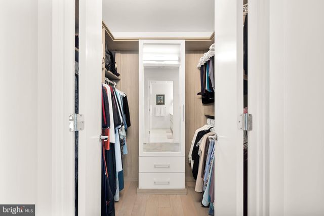 a view of walk in closet with clothes