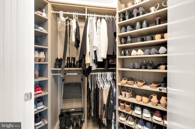 a view of walk in closet with clothes and shoes