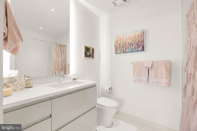 a bathroom with a toilet sink vanity and mirror