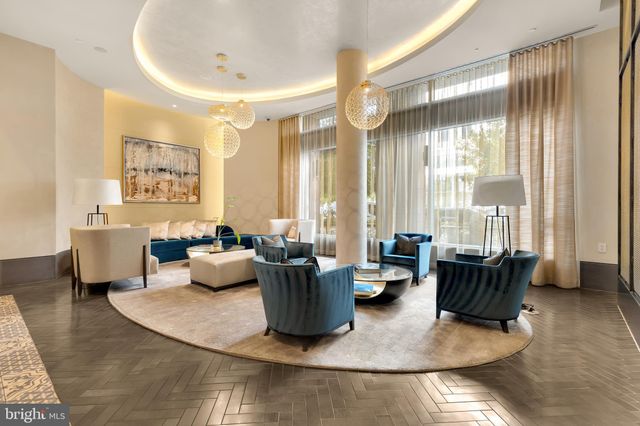 a living room with furniture a flat screen tv and a floor to ceiling window