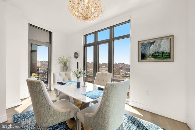 a dining room with furniture a rug and a large window