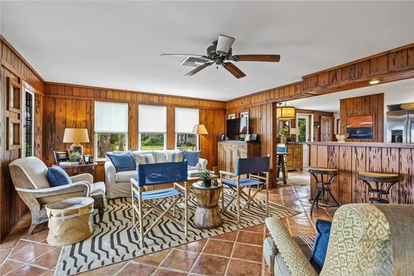 a living room with furniture a fireplace and a floor to ceiling window