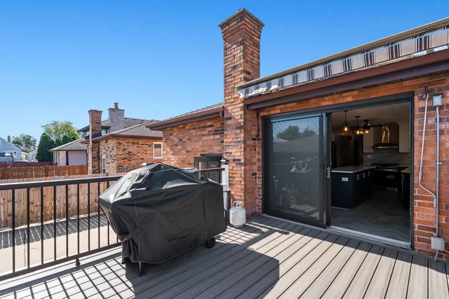 a front view of a house with barbeque and wooden floor