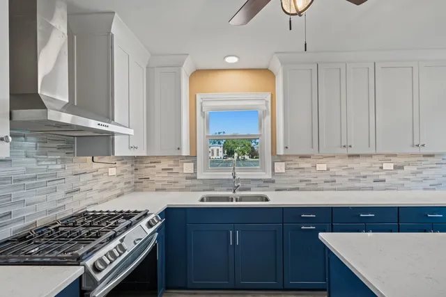 a kitchen with granite countertop a sink a stove and cabinets