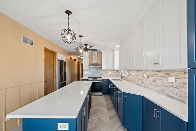 a large kitchen with kitchen island granite countertop a sink a counter space and stainless steel appliances