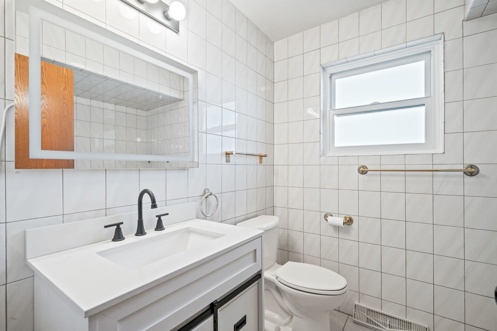 2333 North Trumbull Avenue River Grove, IL 60171 - Photo 9 of 17 a bathroom with a sink a toilet and a window