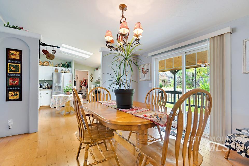 1780 Sand Hollow Road Vale, OR 97918 - Photo 24 of 41 Dining space featuring light wood-style flooring, vaulted ceiling, and a chandelier
