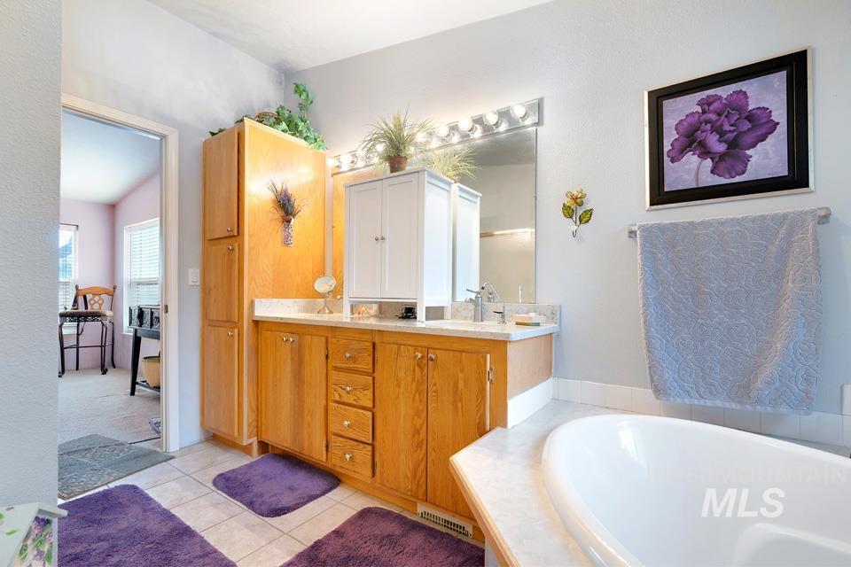 1780 Sand Hollow Road Vale, OR 97918 - Photo 30 of 41 Bathroom featuring double vanity, a bath, and light tile patterned flooring
