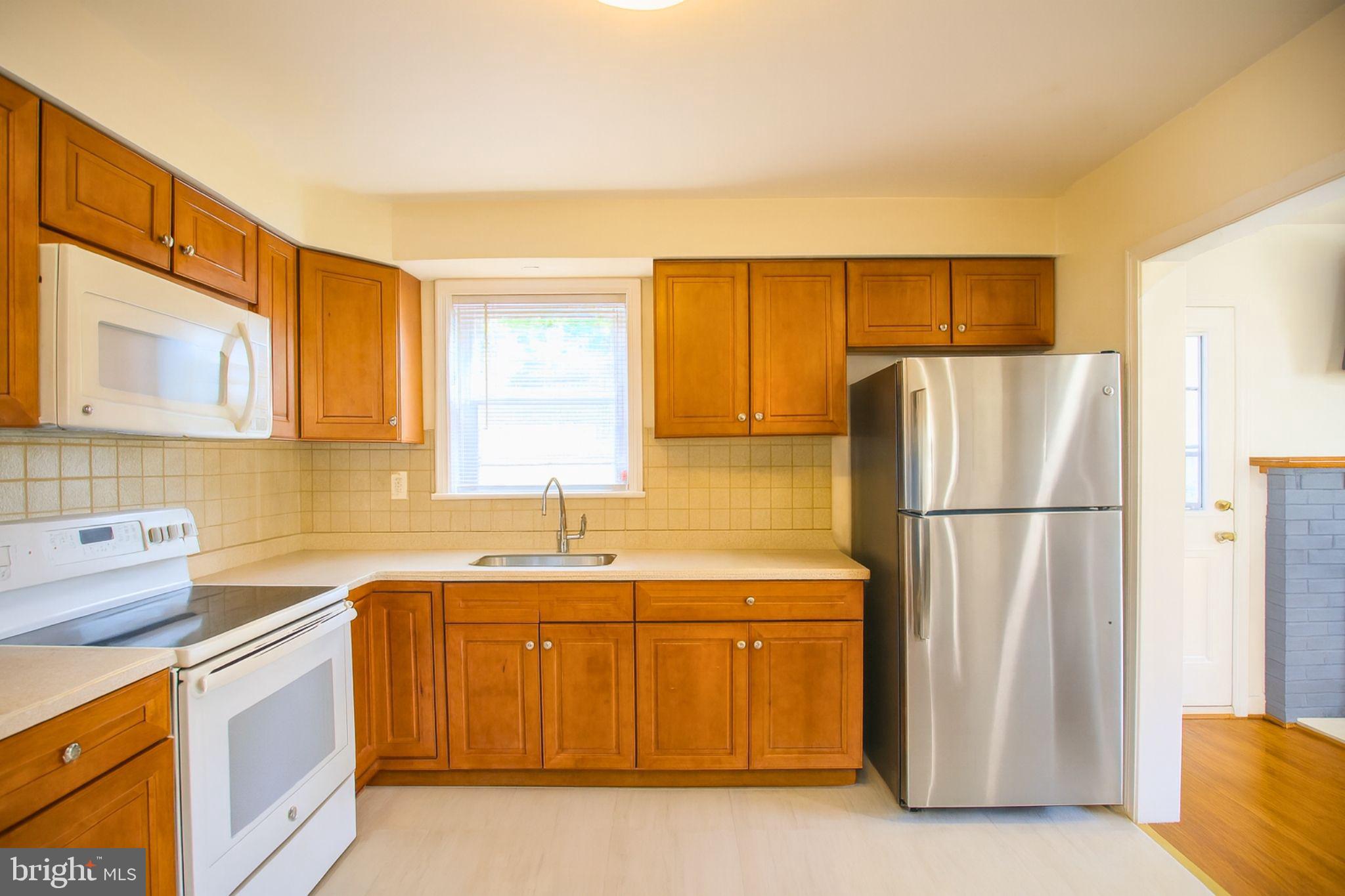 9200 Pine View Lane Clinton, MD 20735 - Photo 7 of 28 a kitchen with stainless steel appliances a refrigerator a sink a stove and white cabinets