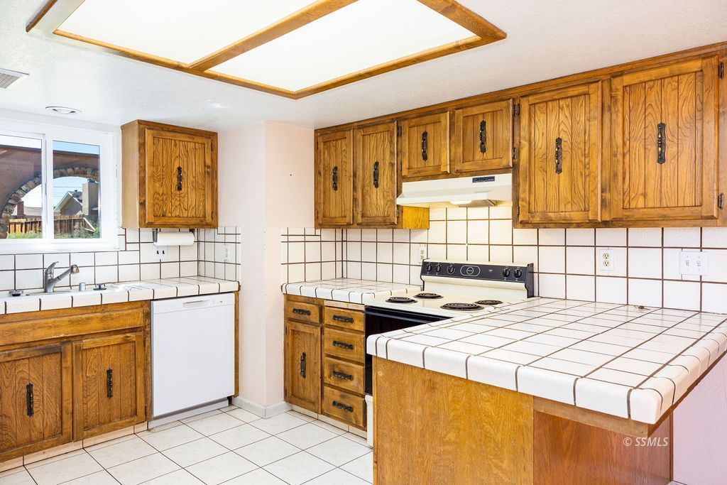 1144 West Benson Avenue Ridgecrest, CA 93555 - Photo 12 of 32 a kitchen that has a sink and a stove