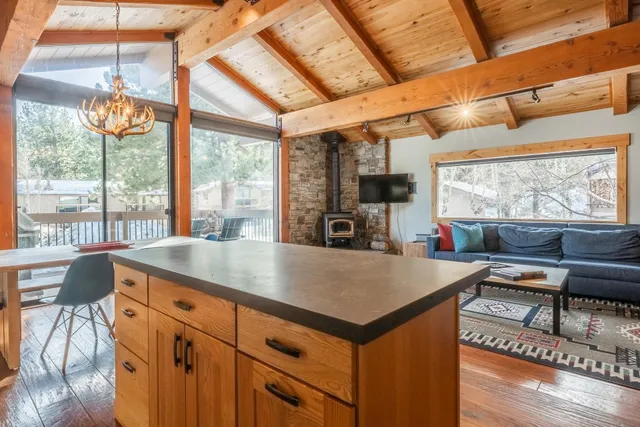 a kitchen with stainless steel appliances granite countertop a sink a stove and a refrigerator with wooden floor