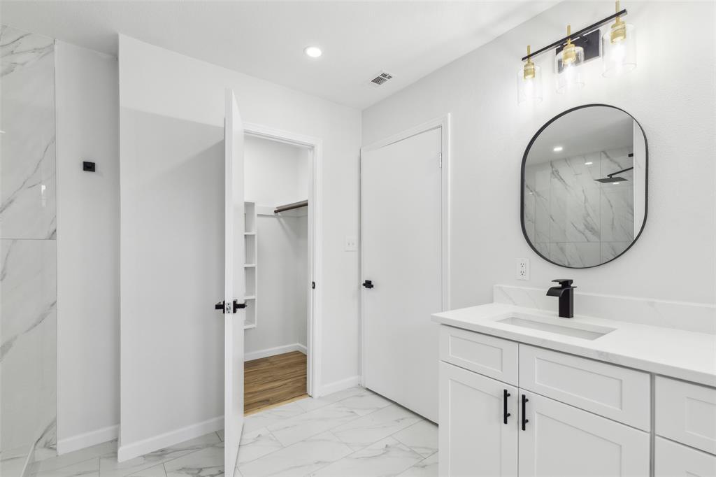 911 Pebblebrook Drive Allen, TX 75002 - Photo 20 of 32 a en suite bathroom with a sink and a mirror