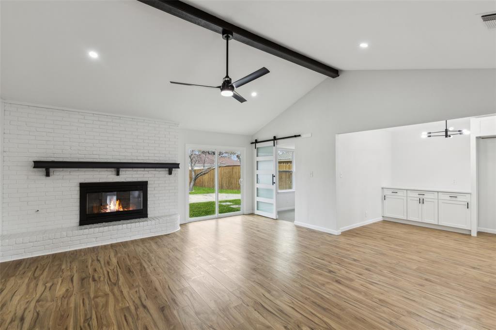 911 Pebblebrook Drive Allen, TX 75002 - Photo 2 of 32 a view of wooden floor fire place and windows in a room