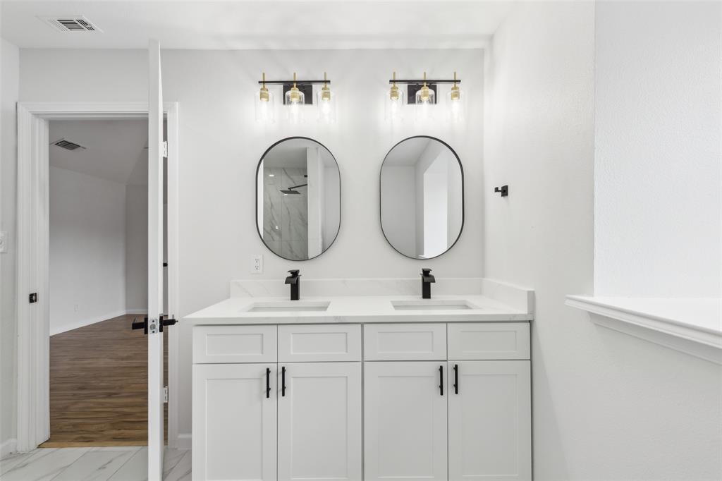 911 Pebblebrook Drive Allen, TX 75002 - Photo 21 of 32 a bathroom with 2 sink and a mirror