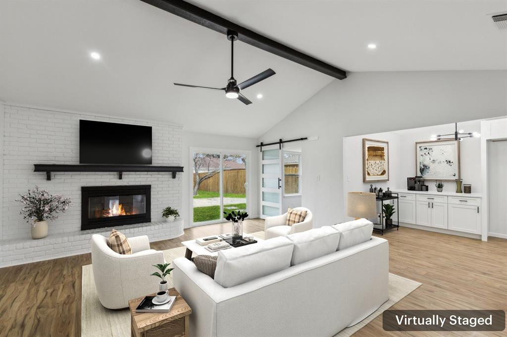 911 Pebblebrook Drive Allen, TX 75002 - Photo 3 of 32 a living room with furniture a fireplace and a flat screen tv