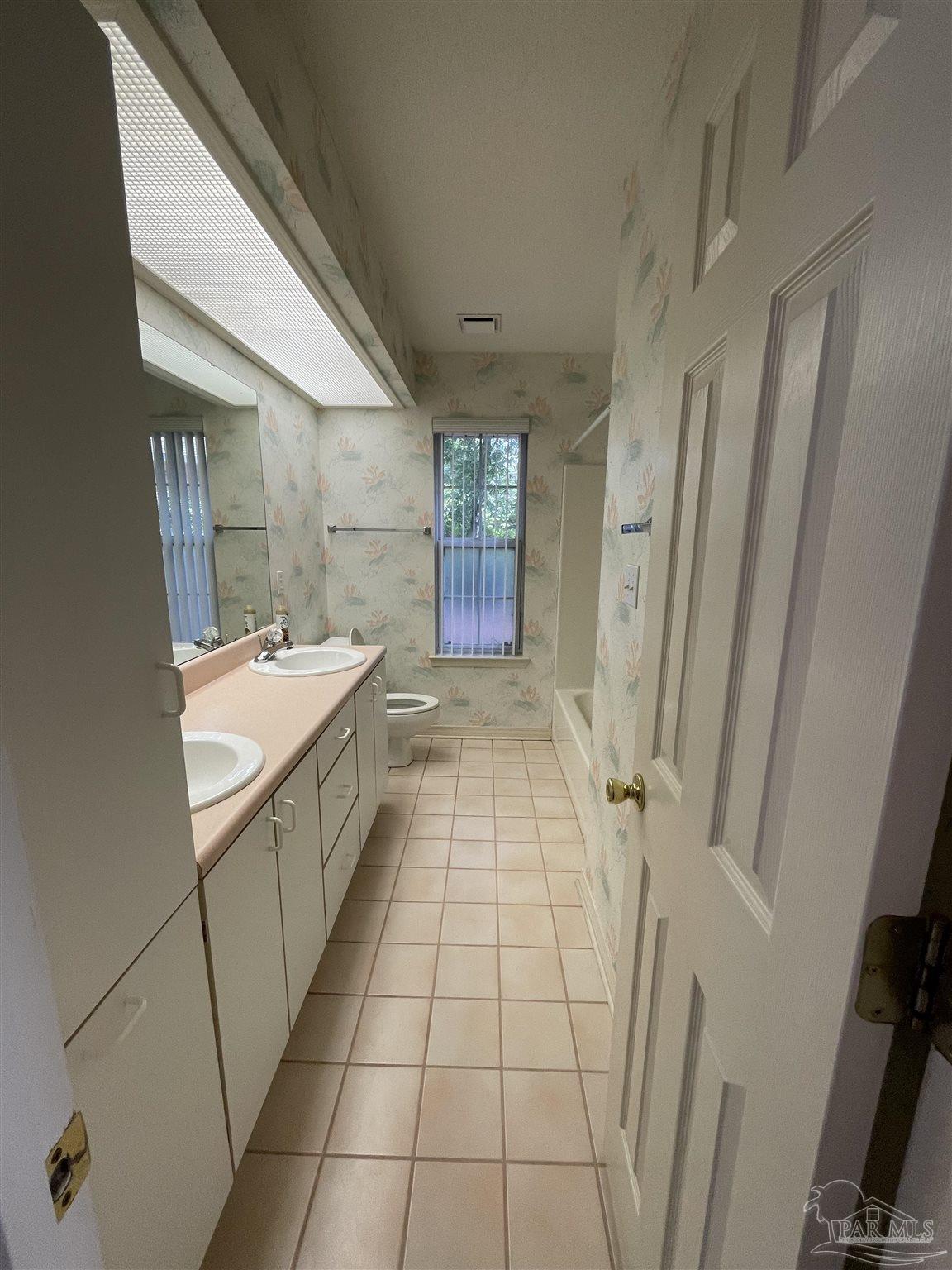 941 Spring Creek Circle Pensacola, FL 32514 - Photo 17 of 30 a bathroom with a sink a mirror and a shower