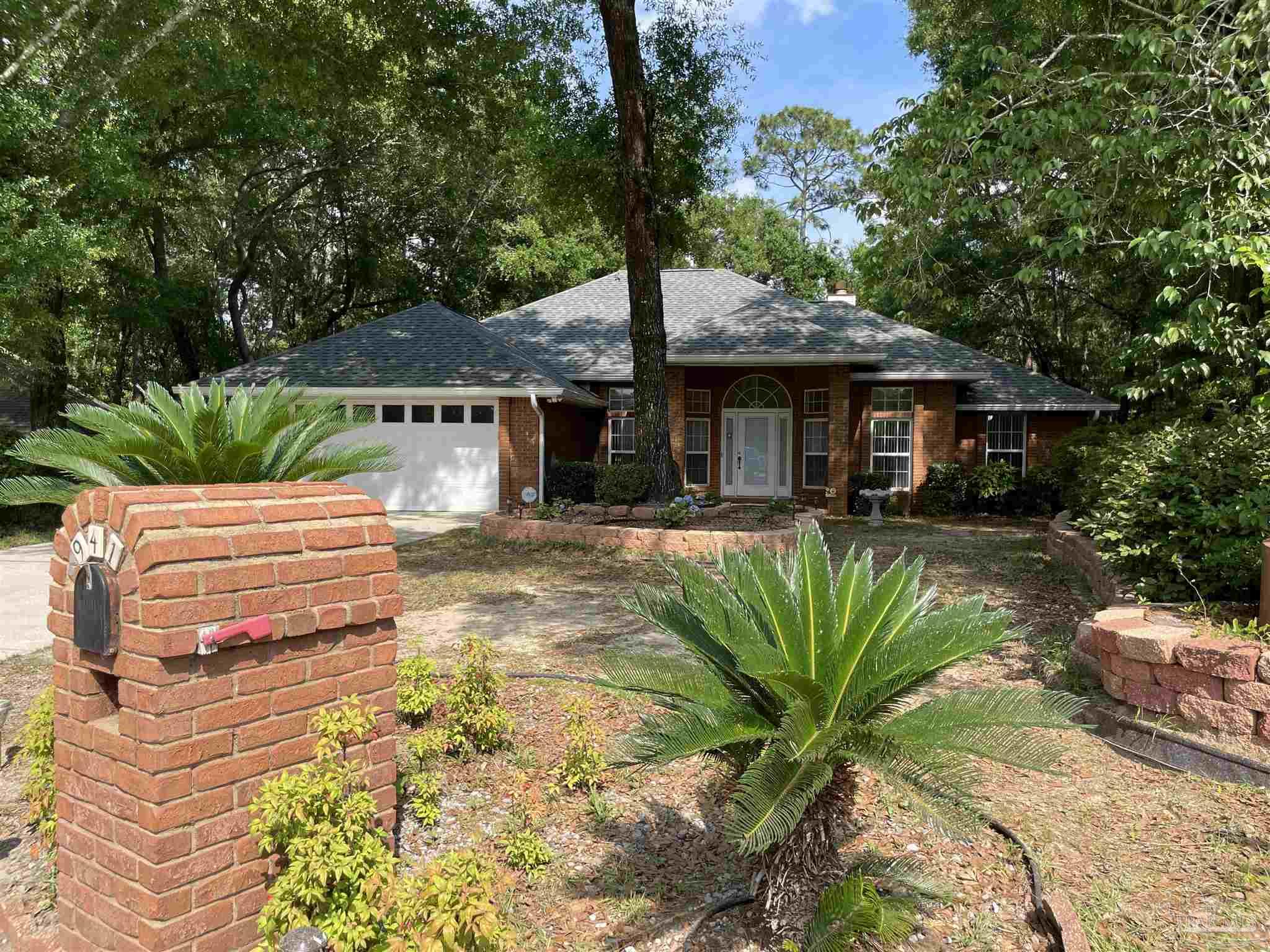 941 Spring Creek Circle Pensacola, FL 32514 - Photo 3 of 30 a view of a patio with table and chairs potted plants and large tree