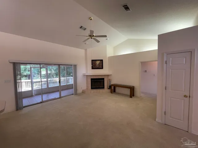 an empty room with windows and fireplace