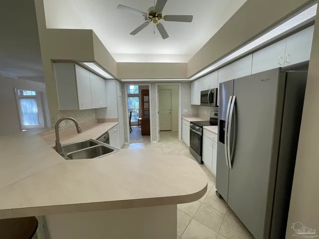 a kitchen with stainless steel appliances a refrigerator sink and stove