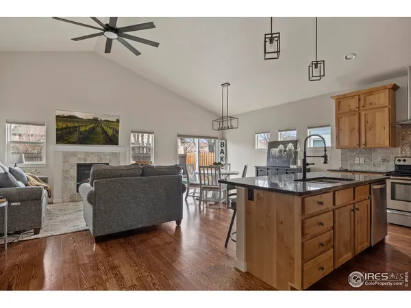 a kitchen with kitchen island granite countertop a sink cabinets and wooden floor